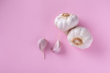 Pembe arka planda sarımsak karanfillerinin üst görüntüsü