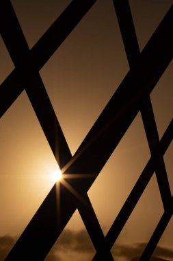 dikey ve yatay çizgiler arka plandaki güneşle bir ızgara oluşturur - soyut geometrik şekil