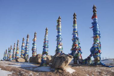 Cape Burhan 'da renkli kurdeleli sütunlar. Şamanizmin kutsal yeri. Baykal Gölü manzarası