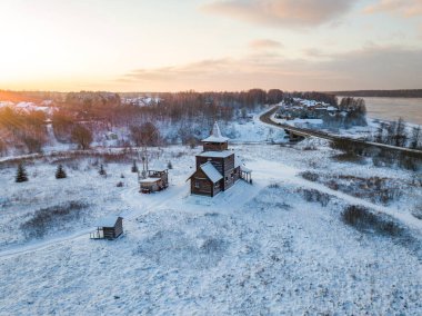 Anninsky kilisesinin bahçesindeki küçük ahşap kilise. Kış akşamı manzarası. Leningrad bölgesi, Rusya