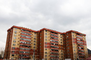 Gökyüzünde benzer renkte ve bulutlu apartmanlar.