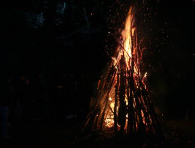 Orman geceleri yanıyor. Dağlardaki turistik kampta kamp ateşi. Soyut arka planda alevler ve ateş kıvılcımları. Cehennem ateşi elementi. Geceleri turuncu ateş