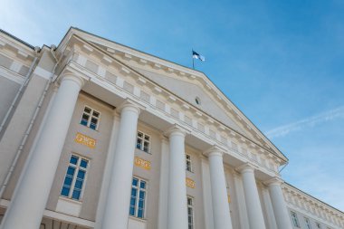 Tartu Üniversitesi ana bina cephe ile Estonya bayrağı üstte, Tartu, Estonya