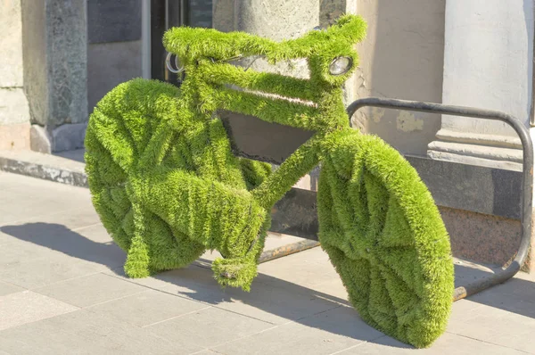 Inusual bicicleta está envuelto con césped artificial verde Imágenes De Stock Sin Royalties Gratis