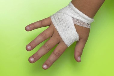 Yeşil backgrou beyaz bir bandaj ile sargılı çocuk kol