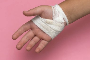 Pembe bir adam beyaz bir bandaj ile sargılı çocuk kol