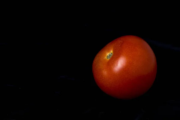 Tomate rojo maduro sobre fondo negro —  Fotos de Stock