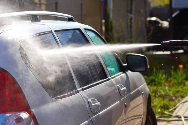 Mycie biały brudny samochód strumieniem wody z machin mycia — Zdjęcie stockowe