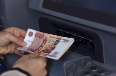 Açık Atm önünde para yığınını almak el tutar