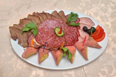 Et dilimleri Yeşiller, zeytin ve beyaz bir tabakta sebze,