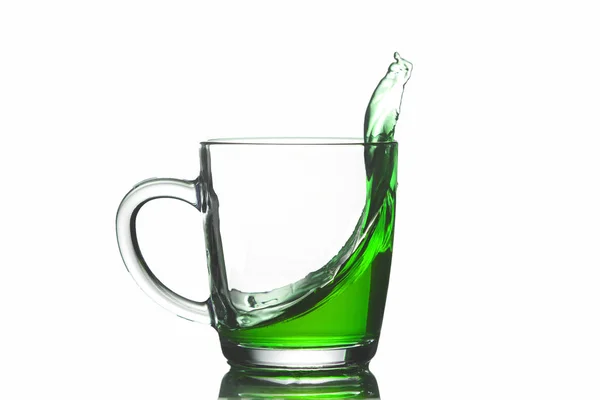 Tazza Trasparente Con Liquido Verde Fuoriuscita Isolamento Primo Piano — Foto Stock