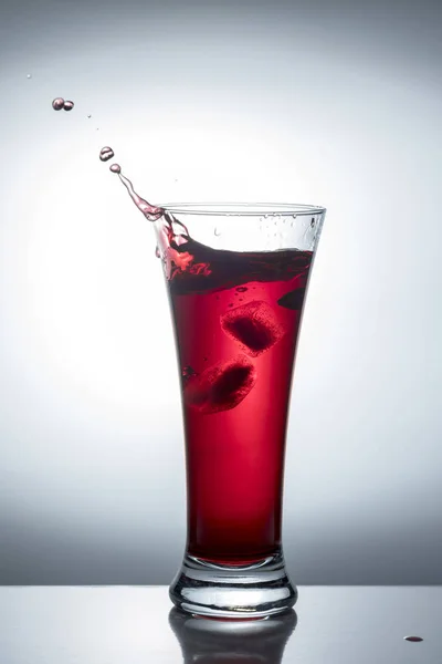 赤ワイン 氷と光の飛沫で透明なガラス — ストック写真