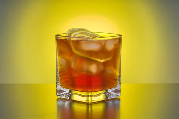 Ttransparent Kieliszek Whisky Lodem Cytryna Tle Źródła Światła Żółty — Zdjęcie stockowe