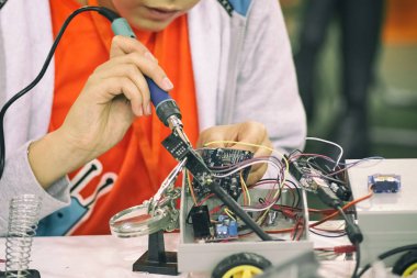 Mühendis ya da teknisyen lehim demiriyle elektronik devre kartını tamir ediyor.