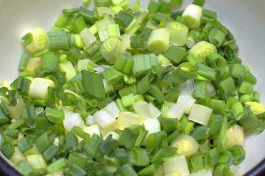 Kase, yakın çekim doğranmış yeşil soğan bir Beyaz Emaye