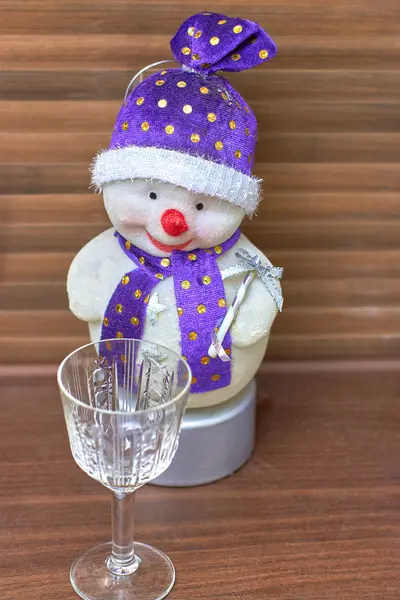 Pupazzo di neve giocattolo guarda un bicchiere vuoto, primo piano — Foto Stock