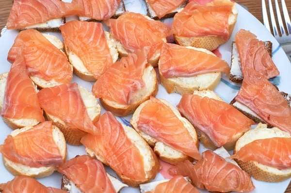 Бутерброди з червоною рибою на білій тарілці крупним планом, текстура і б — стокове фото