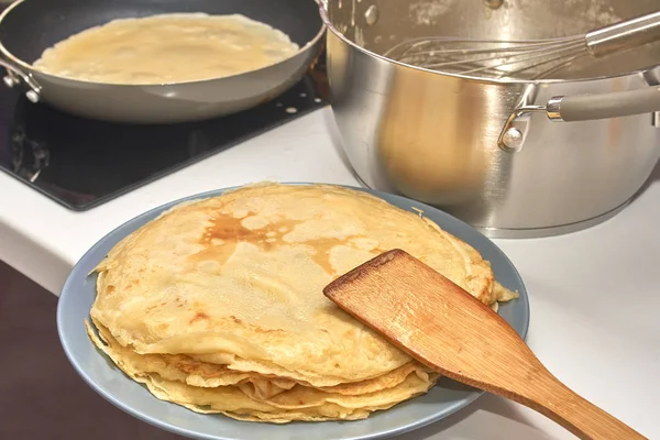 Matlagning pannkakor, visp i en kastrull med smet och en tallrik med ho — Stockfoto