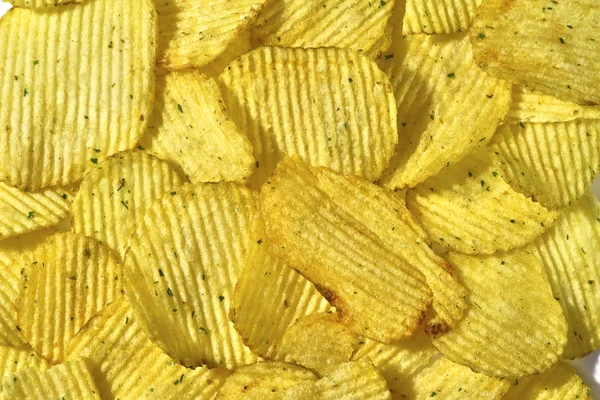 Corrugated potato chips with green onions, close-up food backgro