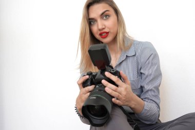 Büyük bir kamera ile güzel genç sarışın kameraya bakar