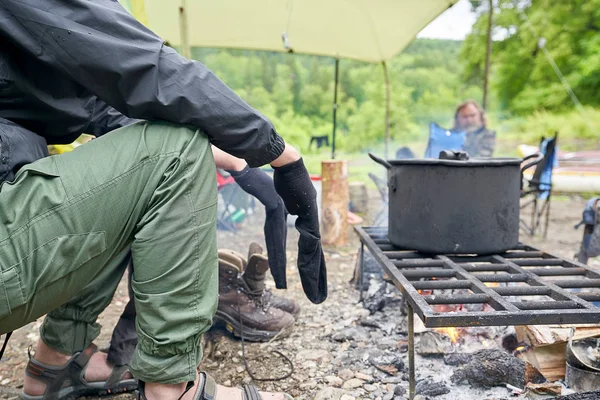 Tourist dries wet socks sitting by the fire. Easy defocus