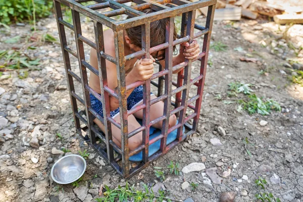 Un niño sucio, magullado y arañado se sienta de rodillas en un corcel — Foto de Stock