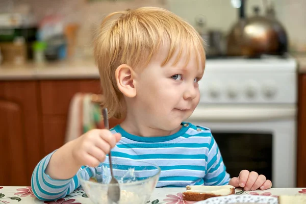 Giocoso ragazzo di tre anni che fa colazione in cucina — Foto Stock