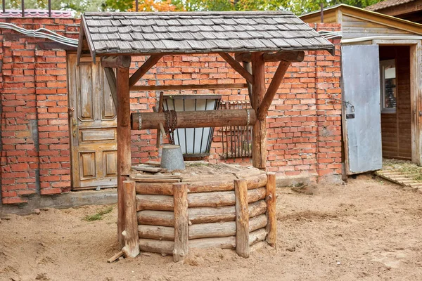Rustieke houten put met een emmer aan een ketting belegd met zand — Stockfoto