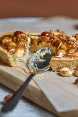 Yuvarlak kahverengi kek sepeti. Kırık kirli kaşık. Masada hala hayat var. Dikey çekim, yakın çekim.