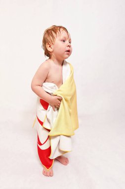 Üç yaşındaki ıslak bir çocuk duşta yıkandıktan sonra banyo havlusuna sarılır. Kişisel hijyen. Dikey çekim