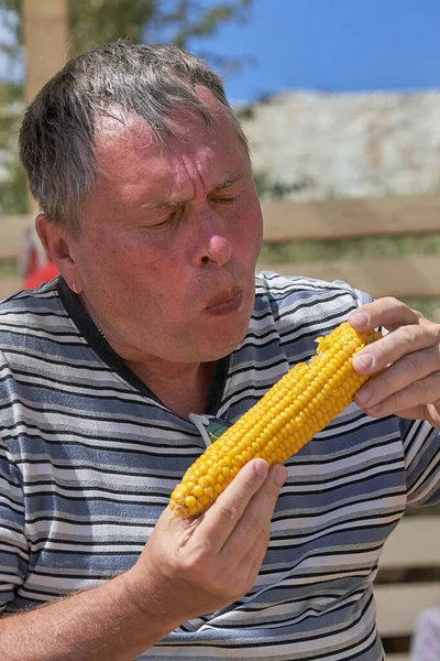 Portret Mężczyzny Średnim Wieku Jedzącego Żółte Ucho Gotowanej Kukurydzy Strzał — Zdjęcie stockowe