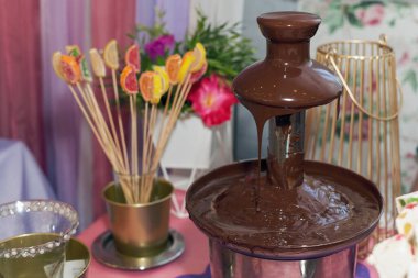 Bir çikolata çeşmesi, şenlikli tatlı bir masada yakın plan.