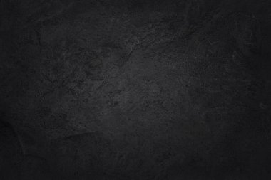 Koyu gri kayrak dokusu yüksek çözünürlüklü, arka planda siyah taş duvar var..
