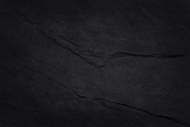 Koyu gri kayrak dokusu yüksek çözünürlüklü, arka planda siyah taş duvar var..