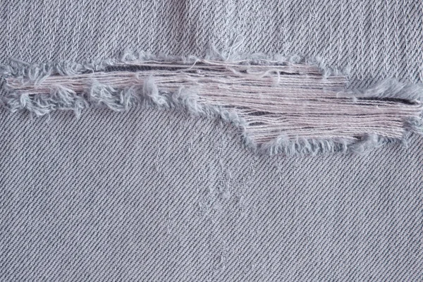 Kot pantolon üzerindeki yırtık ve eski desen, arka plan için ayrıntılı kot dokusu.