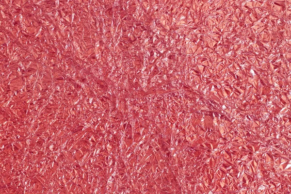 Gül sarısı folyo parlak doku, arkaplan ve tasarım çalışmaları için soyut kırmızı ambalaj kağıdı.