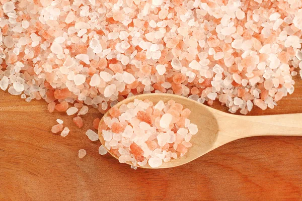 top view of himalayan pink salt in wooden spoon on the table with copy space.