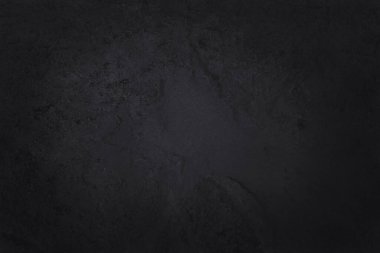 Koyu gri kayrak dokusu yüksek çözünürlüklü, arka planda siyah taş duvar var..