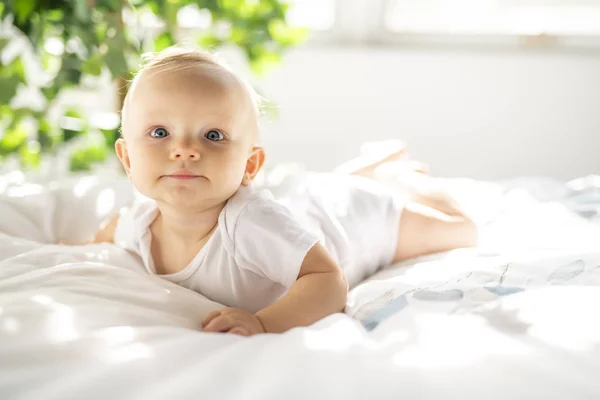 Mignon bébé fille couché sur une feuille blanche à la maison — Photo