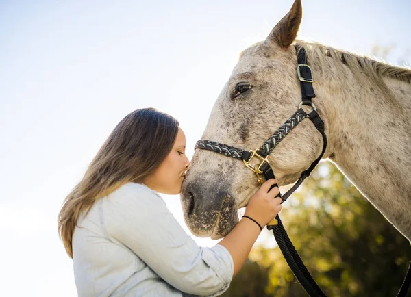 Ein schönes Teenie-Mädchen auf dem Bauernhof mit ihrem Pferd. — Stockfoto