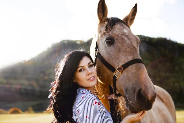 Una mujer con su caballo al atardecer, escena de otoño al aire libre —  Fotos de Stock