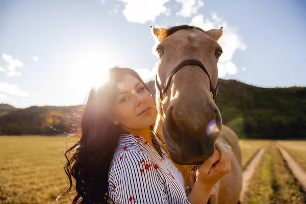 夕日、秋の屋外でのシーンで彼女の馬を持つ女性 — ストック写真