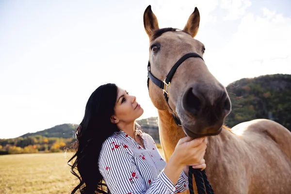 夕日、秋の屋外でのシーンで彼女の馬を持つ女性 — ストック写真