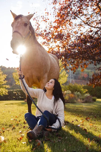 Uma mulher com seu cavalo ao pôr do sol, cena Outono ao ar livre — Fotografia de Stock