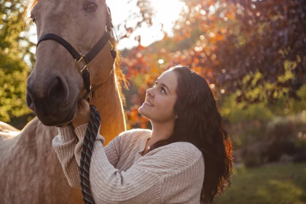 Uma mulher com seu cavalo ao pôr do sol, cena Outono ao ar livre — Fotografia de Stock