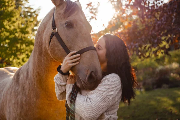 Uma mulher com seu cavalo ao pôr do sol, cena Outono ao ar livre — Fotografia de Stock