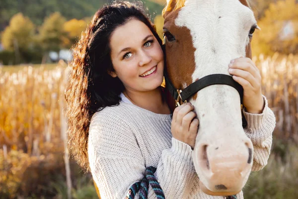 夕日、秋の屋外でのシーンで彼女の馬を持つ女性 — ストック写真