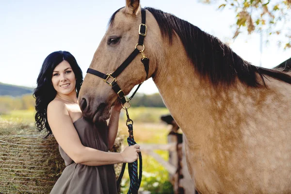 Un retrato de una joven hermosa mujer con caballo marrón al aire libre —  Fotos de Stock