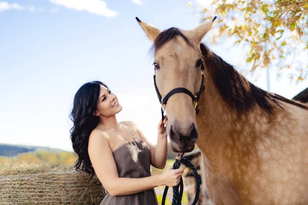 Un retrato de una joven hermosa mujer con caballo marrón al aire libre —  Fotos de Stock