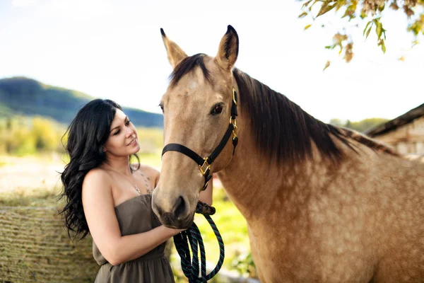 Um retrato de jovem mulher bonita com cavalo marrom ao ar livre — Fotografia de Stock